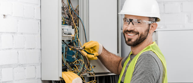 An electrician working on the electrical panel 